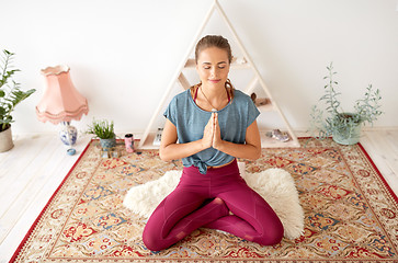 Image showing woman meditating in lotus pose at yoga studio