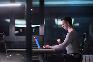 Image showing man working on laptop in dark office