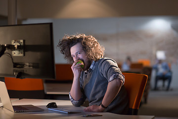 Image showing man eating apple in his office