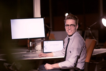 Image showing man working on computer in dark office