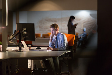 Image showing man working on computer in dark office