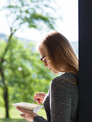 Image showing woman eating breakfast in front of her luxury home villa