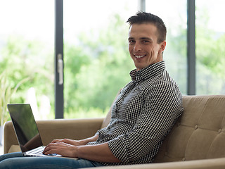 Image showing Man using laptop in living room