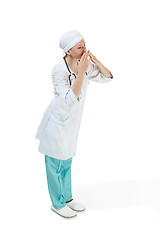 Image showing Beautiful young woman is sending an air kiss in white coat posing at studio. Full length studio shot isolated on white.