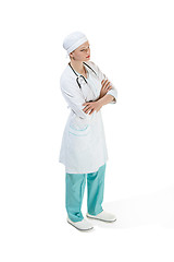 Image showing Beautiful young woman is standing seriously in white coat posing at studio. Full length studio shot isolated on white.