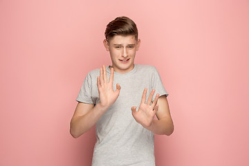 Image showing Let me think. Doubtful pensive man with thoughtful expression making choice against pink background