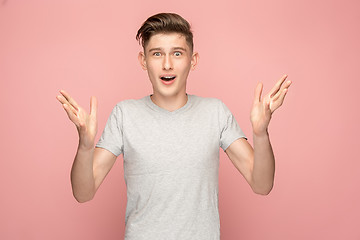 Image showing The young attractive man looking suprised isolated on pink