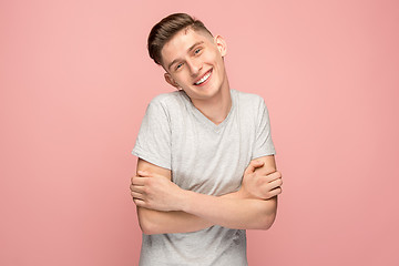 Image showing The happy businessman standing and smiling against pink background.