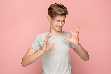 Image showing Let me think. Doubtful pensive man with thoughtful expression making choice against pink background