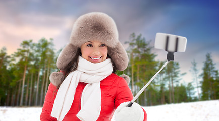 Image showing happy woman taking selfie over winter forest