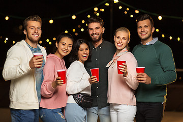 Image showing friends with party cups on rooftop at night