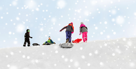 Image showing kids with sleds climbing snow hill in winter