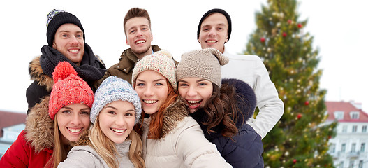 Image showing happy friends over christmas tree in old tallinn