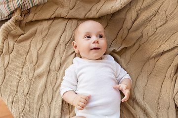 Image showing sweet little baby boy lying on knitted blanket