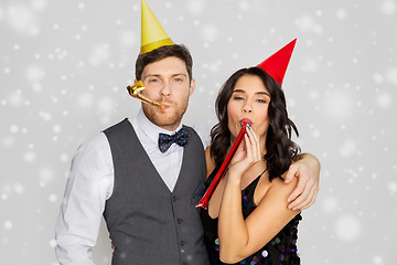 Image showing happy couple with party blowers having fun