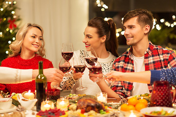 Image showing happy friends drinking red wine at christmas party