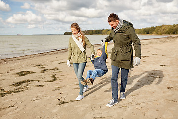 Image showing happy family walking along autumn beach