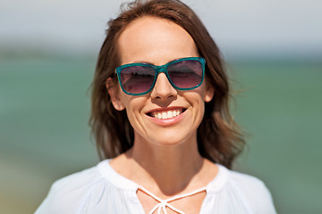 Image showing happy smiling woman in sunglasses on summer beach
