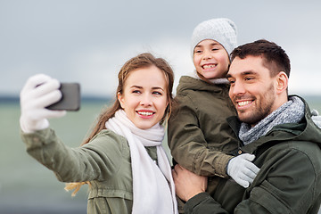 Image showing family taking selfie by smartphone on autumn beach