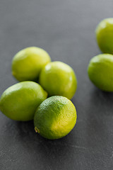 Image showing close up of whole limes on slate table top