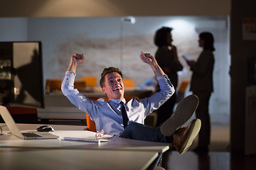 Image showing businessman sitting with legs on desk at office