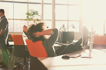 Image showing businessman sitting with legs on desk