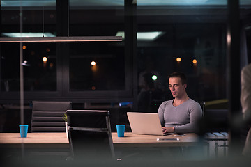 Image showing man working on laptop in dark office