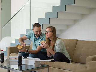 Image showing couple eating pizza in their luxury home villa