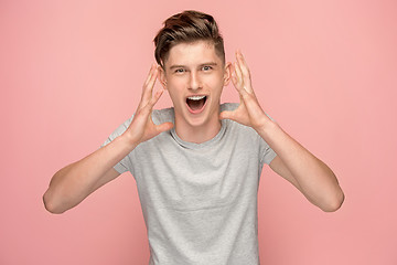 Image showing Isolated on pink young casual man shouting at studio