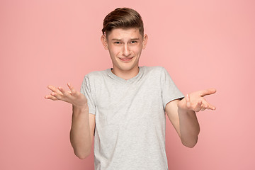 Image showing Suspiciont. Doubtful pensive man with thoughtful expression making choice against pink background