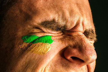 Image showing Portrait of a man with the flag of the Brazil painted on him face.