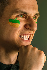 Image showing Portrait of a man with the flag of the Brazil painted on him face.