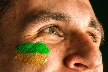 Image showing Portrait of a man with the flag of the Brazil painted on him face.