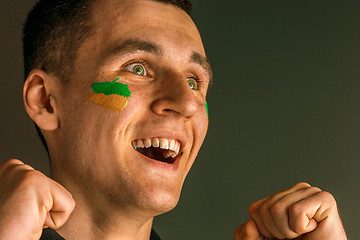 Image showing Portrait of a man with the flag of the Brazil painted on him face.