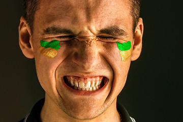 Image showing Portrait of a man with the flag of the Brazil painted on him face.