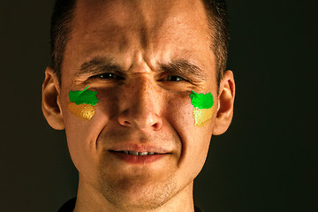 Image showing Portrait of a man with the flag of the Brazil painted on him face.