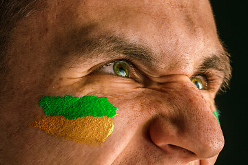 Image showing Portrait of a man with the flag of the Brazil painted on him face.