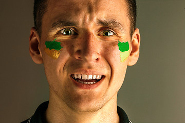 Image showing Portrait of a man with the flag of the Brazil painted on him face.