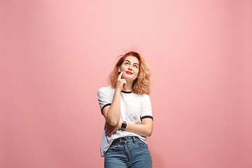 Image showing Let me think. Doubtful pensive woman with thoughtful expression making choice against pink background