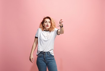 Image showing Beautiful female half-length portrait isolated on pink studio backgroud. The young emotional surprised woman