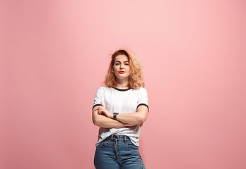 Image showing The serious business woman standing and looking at camera against pink background.