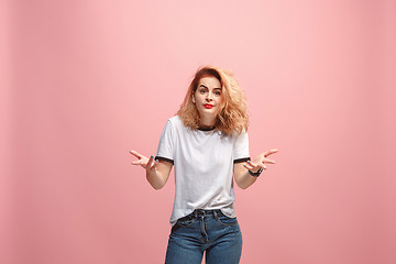 Image showing Beautiful female half-length portrait isolated on pink studio backgroud. The young emotional surprised woman