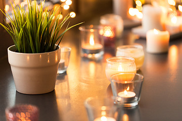 Image showing candles burning on window sill with garland lights