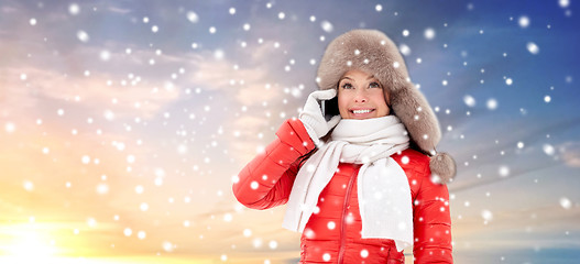 Image showing happy woman in winter hat calling on smartphone