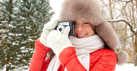 Image showing happy woman with film camera over winter forest