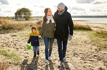 Image showing happy family walking along autumn beach