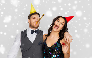 Image showing happy couple with party blowers having fun