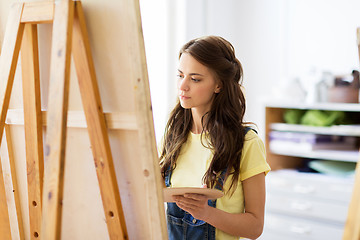 Image showing student girl with easel painting at art school