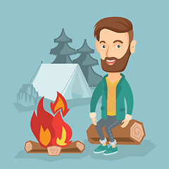 Image showing Man sitting on log near campfire in the camping.