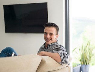 Image showing man on sofa using tablet computer